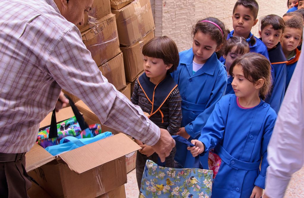 Aid worker delivering kits to children